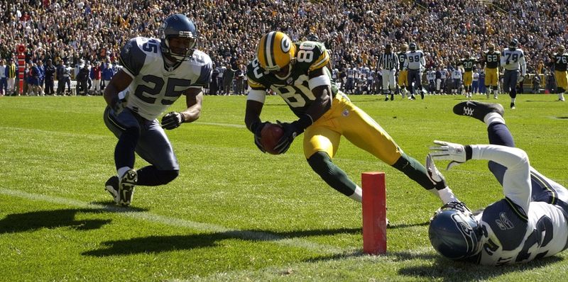 Green Bay Packers wide receiver Donald Driver scores a touchdown despite the efforts of Seattle Seahawks Reggie Tongue (25) and Marcus Trufant (23) during the first quarter of their game Sunday, October 5, 2003 at Lambeau Field in Green Bay, Wis.