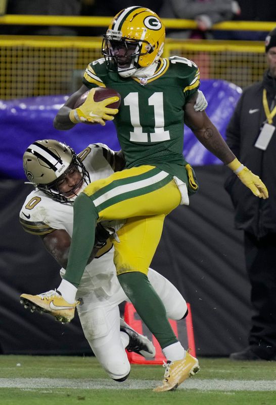 Green Bay Packers wide receiver Jayden Reed makes a 34-yard reception before being tackled by New Orleans Saints safety Ugo Amadi.