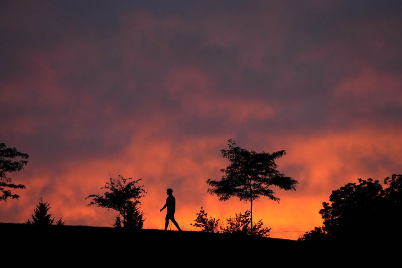 Danny Azimov, of Bayside walks up the the sled hill as the sun sets on N. Regent Roan in Bayside on Tuesday, July 9, 2024.
