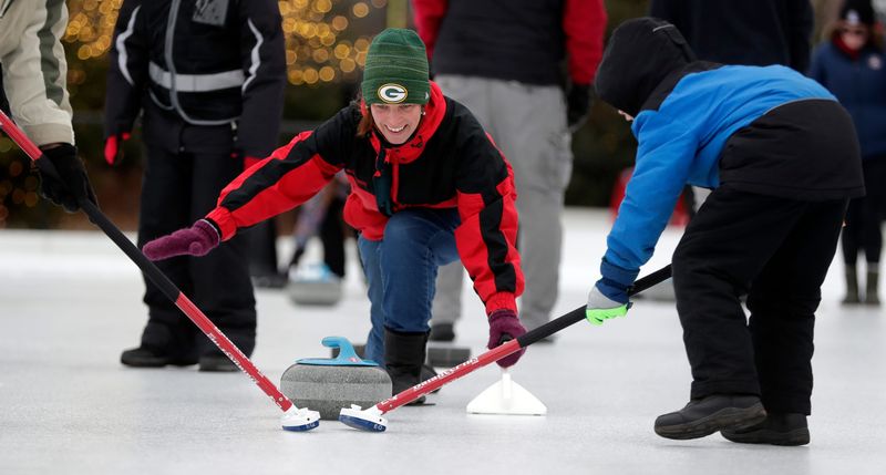 Event attendees try the curling during the Titletown Winter Games on Feb. 1, 2025, at Green Bay Packers' Titletown District in Ashwaubenon, Wis.