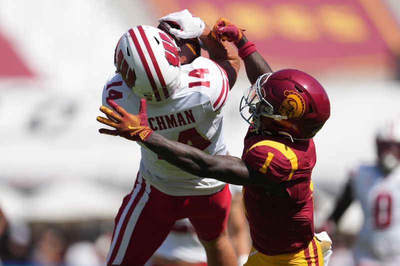 Sep 28, 2024; Los Angeles, California, USA; Wisconsin Badgers safety Preston Zachman (14) intercepts a pass intended for Southern California Trojans wide receiver Zachariah Branch (1) in the first half at United Airlines Field at Los Angeles Memorial Coliseum. Mandatory Credit: Kirby Lee-Imagn Images