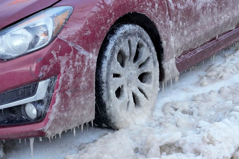 A car is frozen in ice on North Franklin Place, just north of East Pleasant Street in Milwaukee on Thursday, Feb. 20, 2025. Several vehicles on the block remained stuck in the ice after a water main broke at 1126 E. Pleasant St. on Tuesday afternoon.