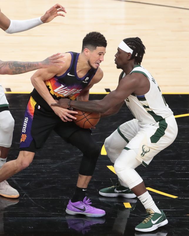Phoenix Suns guard Devin Booker (1) has the ball stolen by Milwaukee Bucks guard Jrue Holiday (21) in the final seconds during Game 5 of the NBA Finals on July 17, 2021.