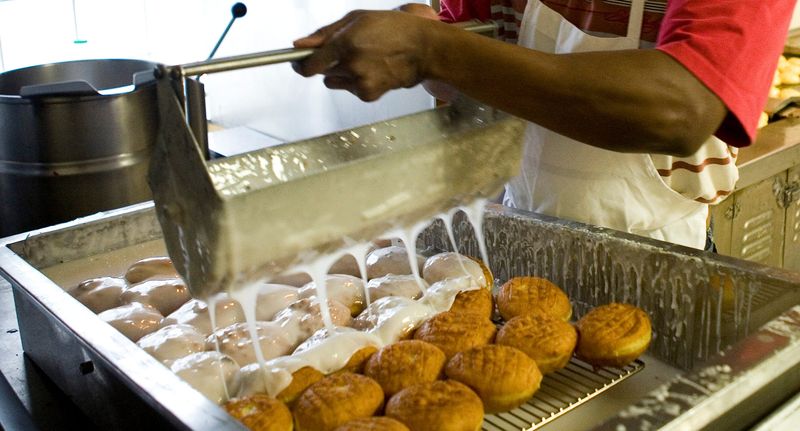 A glaze is applied to paczki at National Bakery & Deli on February 15, 2010. About 45,000 paczkis were made for Fat Tuesday, some with butter dough and others with plain dough.