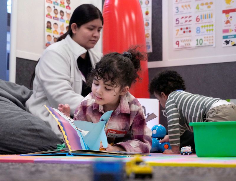 5-year-old Zahari Westfahl looks through a book as Briana Martinez, an education student, plays with 2-year-old Ziyad Salem at Milwaukee Area Technical College’s new drop-in child care center at its downtown campus in Milwaukee on Tuesday, March 4, 2025.