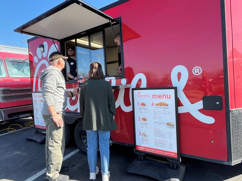 Customers order from the Chick-fil-A Tri-State Food Truck. The menu offers chicken sandwiches, chicken nuggets, a wrap and a salad with various sides and beverages.