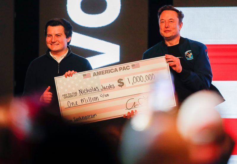 Billionaire Elon Musk presents a check for $1 million made out to Nicholas Jacobs during a town hall on Sunday, March 30, 2025, at the KI Convention Center in Green Bay, Wis. Musk held the event to drive turnout for the state Supreme Court election between Brad Schimel and Susan Crawford.
