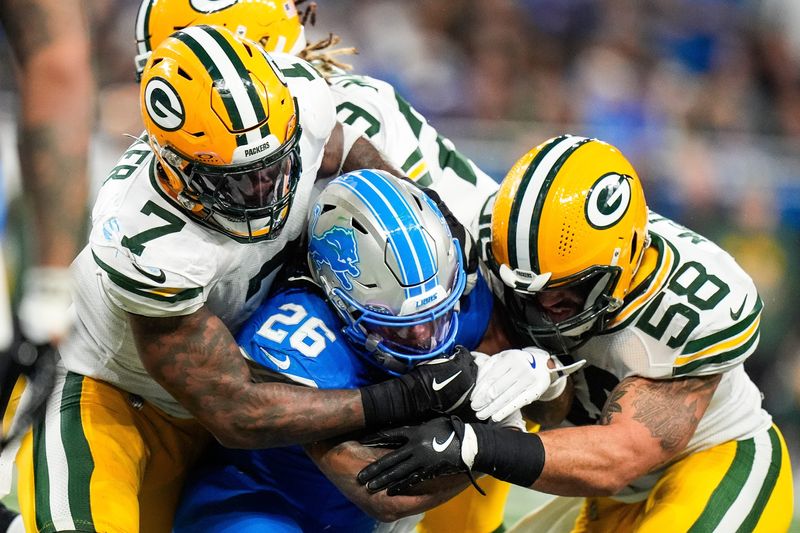 Detroit Lions running back Jahmyr Gibbs (26) runs against Green Bay Packers linebacker Quay Walker (7) and linebacker Isaiah McDuffie (58) during the second half at Ford Field in Detroit on Thursday, Dec. 5, 2024.