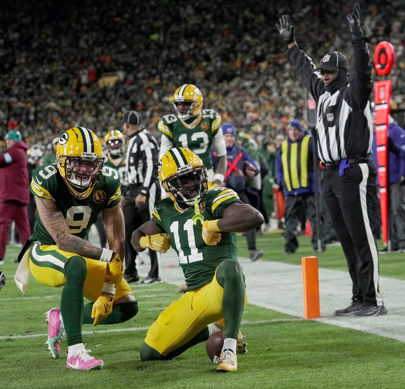 Green Bay Packers wide receiver Jayden Reed (11) celebrates his touchdown reception with wide receiver Christian Watson (9) during the second quarter of their game against the Miami Dolphins, Thursday, November 28, 2024 at Lambeau Field in Green Bay, Wisconsin.