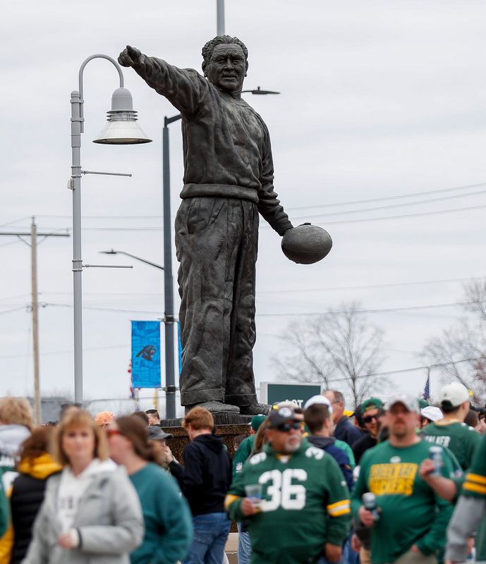 A statue of Green Bay Packers founder Earl L. "Curly" Lambeau towers over fans as they make their way toward the Draft Theater during the first day of the 2025 NFL Draft on Thursday, April 24, 2025, at Lambeau Field in Green Bay, Wisconsin. The draft begins at 7 p.m. CT April 24 and runs through April 26.