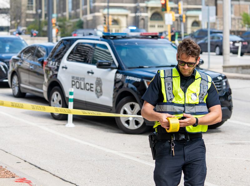 Milwaukee police officer places police tape outside the perimeter of the Zeidler Municipal Building on Thursday May 15, 2025 in Milwaukee, Wis.