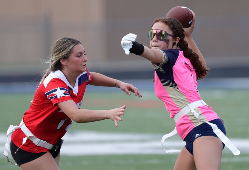Appleton North's Ella Whittington passes under pressure from Appleton East's Megan Lemke during a 2025 flag football game.