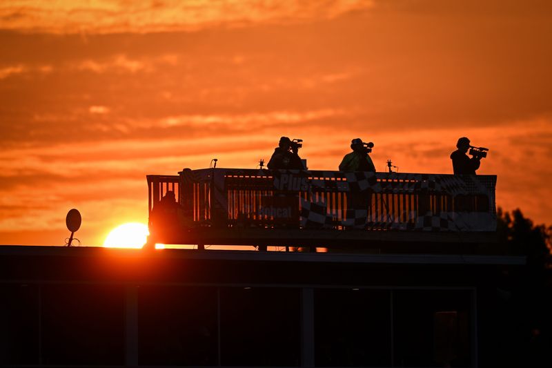 Videographers stand on a deck on a suite building as the sun sets during the El Bandido Yankee Tequila 300 Sunday, June 15, 2025, at Slinger Speedway in Slinger, Wisconsin.