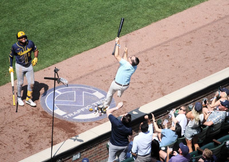 Cubs fan Lou Farinella of Des Plaines, Illinois, climbs the netting at Wrigley Field to retrieve Sal Frelick's bat during the sixth inning of the game between the Brewers and Cubs on June 19, 2025.