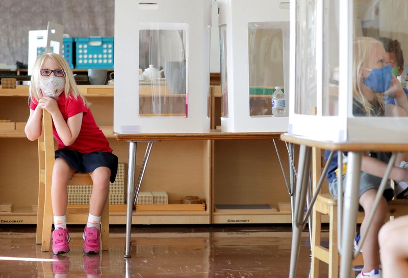 A student in a K3-K5 class sits at her desk with protective barriers as a COVID safety measure during the first day of school at MacDowell Montessori School on Mt. Vernon Avenue in Milwaukee on Aug. 16, 2021.
