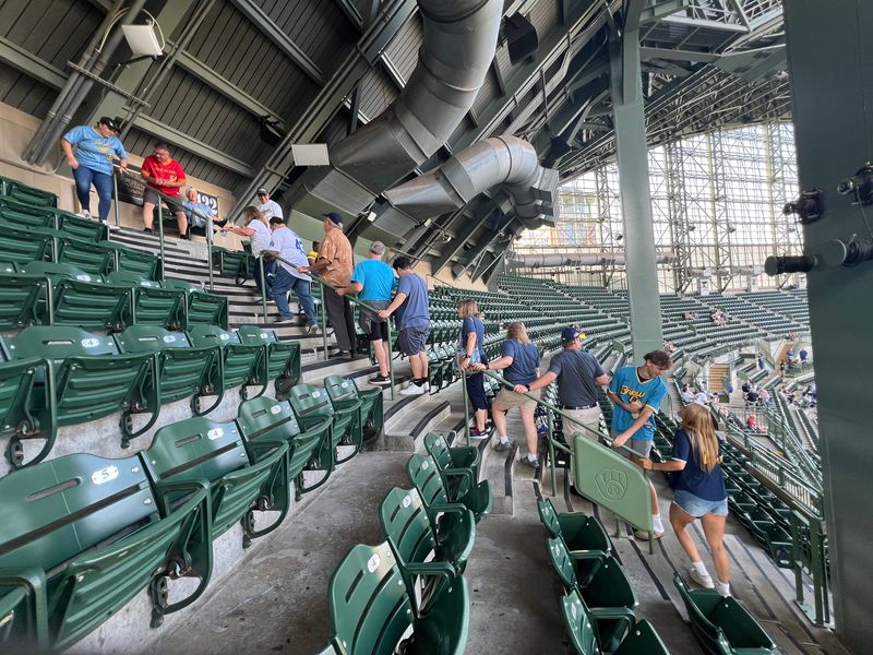 Fans lined up to take photos in the Bob Uecker seats at American Family Field before the Milwaukee Brewers game.
