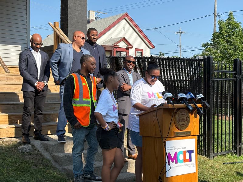 Jeanette Torres, accompanied by her husband, Jovan Jiron, and their daughter, speaks at a press event celebrating the completion of their new home. The Milwaukee Community Land Trust, with other partners, renovated the home and made it affordable for the family.