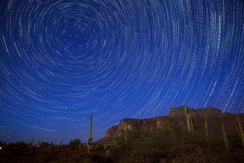 Star trails and a meteor from the Perseid meteor shower can be seen Aug. 14, 2016 beyond the Superstition Mountains in Apache Junction in Arizona.