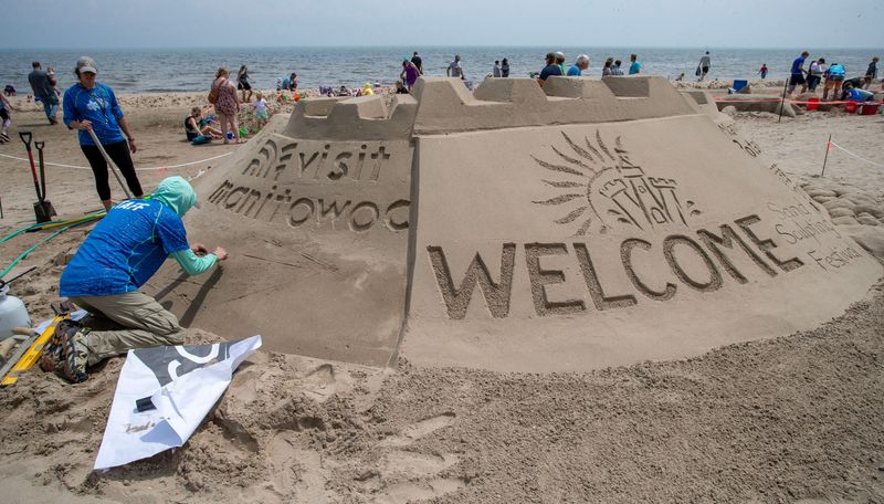 Bob Lechtenberg, of Hartland, Wis., works on a Welcome sand sculpture during the Wisconsin Sand Sculpting Festival at Red Arrow Park, Saturday, July 19, 2025, in Manitowoc, Wis.