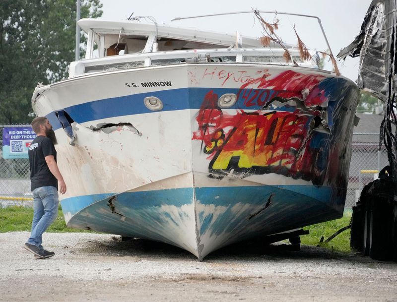 Jeff Piller owner of Jeff's All City Towing, looks inside the boat Deep Thought at Jeff's All City Towing in Milwaukee on July 22, 2025. Milwaukee County Parks held a press conference to announce the opening of a two week online auction for the abandon boat, a Chris-Craft Roamer named Deep Thought that was stranded for months along the Lake Michigan shoreline.