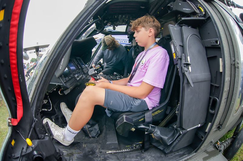 Jacob Ewert, of Denver, Colorado, checks out the pilot’s seat of the Wisconsin Army National Guard UH-60 Blackhawk helicopter during the third day of EAA AirVenture 2025 at Wittman Regional Airport, Wednesday, July 23, 2025, in Oshkosh, Wis.