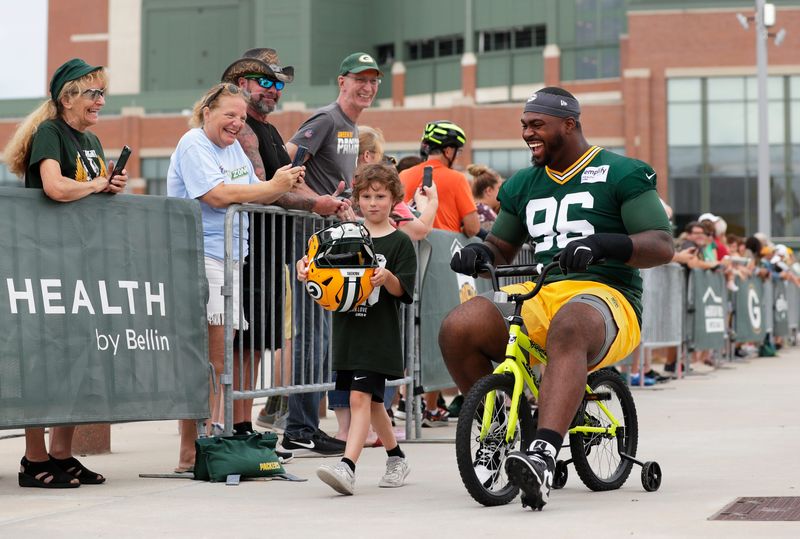 Green Bay Packers defensive tackle Colby Wooden (96) laughs as he participates in the Dream Drive bicycle ride during the second day of training camp on July 24, 2025, in Green Bay, Wis.