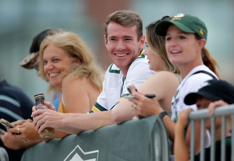 Fans watch Green Bay Packers players participate in the Dream Drive bicycle ride during the second day of training camp on July 24, 2025, in Green Bay, Wis.