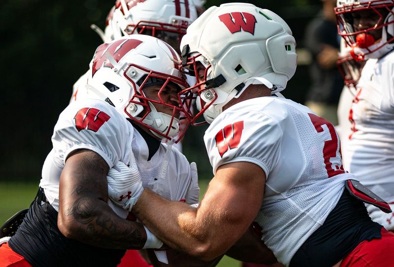 Pushing towards each other, the players are reminded to fully use their helmets throughout the drill during the Wisconsin Football Fall Camp at the Butch E. Leitl Field at Ralph E. Davis Pioneer Stadium in Platteville, Wisconsin, on July 31, 2025.