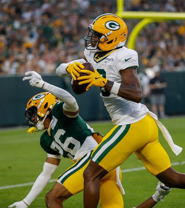 Green Bay Packers wide receiver Malik Heath (18) catches a pass over cornerback Micah Robinson (26) during Family Night on Saturday, August 2, 2025, at Lambeau Field in Green Bay, Wis. 
Tork Mason/USA TODAY NETWORK-Wisconsin