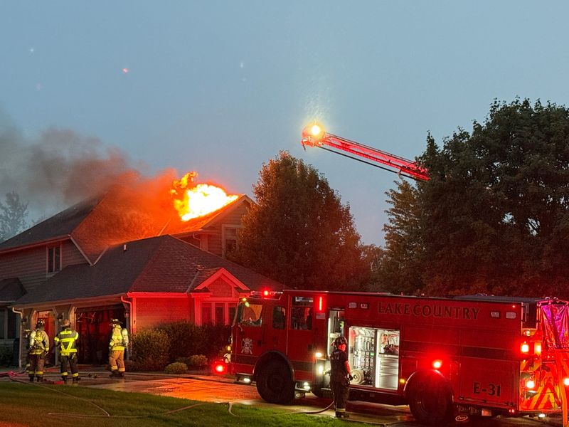Flames can be seen coming from the roof of a Huntsman Court home in the Town of Delafield early Tuesday, Aug. 12. A lightning strike is believed to have caused the fire, which caused an estimated $300,000 damage.