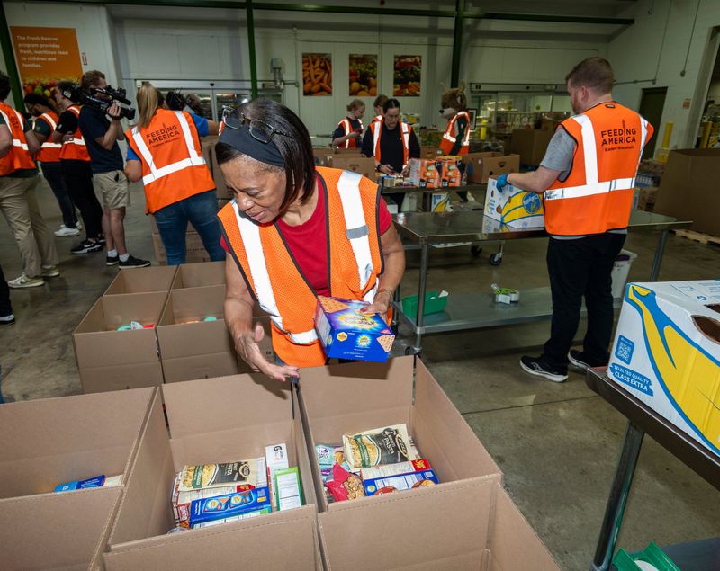 Veola Jackson helps pack grocery boxes after a press conference announcing Milwaukee Bucks forward Bobby Portis (#9) joining the board of Feeding America Eastern Wisconsin on Tuesday August 12, 2025 at Feeding America Eastern Wisconsin-Milwaukee in Milwaukee, WI.