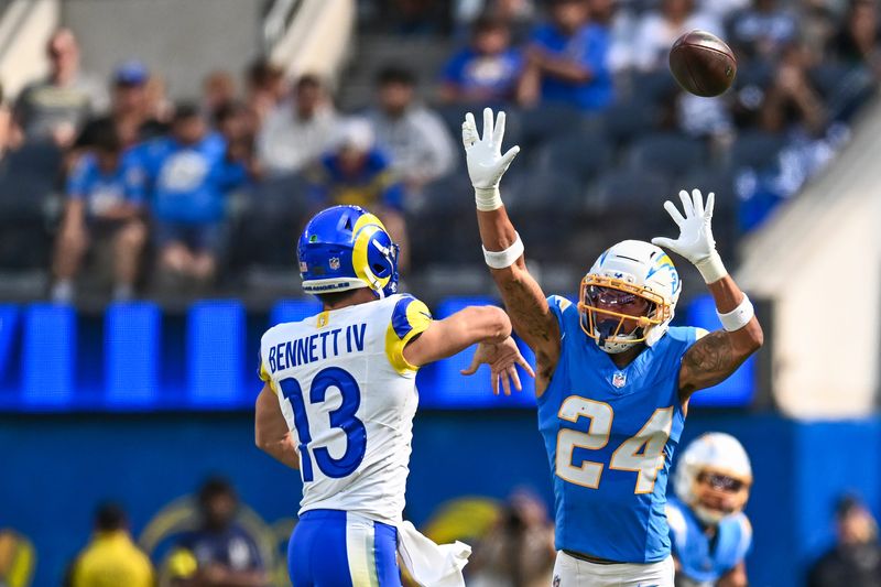 Aug 16, 2025; Inglewood, California, USA; Los Angeles Chargers cornerback Benjamin St-Juste (24) attempts to block a pass against Los Angeles Rams quarterback Stetson Bennett IV (13) during the first quarter at SoFi Stadium. Mandatory Credit: Jonathan Hui-Imagn Images