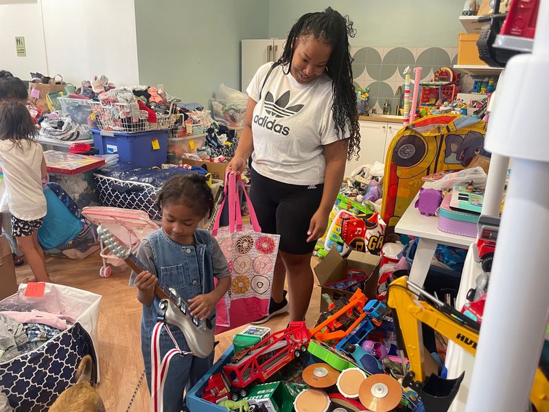Alyssa Caballero, 36, lost many items in her basement, considered the family playroom. As her family comes to terms with the damage, Caballero takes a break to give her 3-year-old son Joel a chance to get new toys, including a toy guitar, at Little Geese Shop in Wauwatosa.