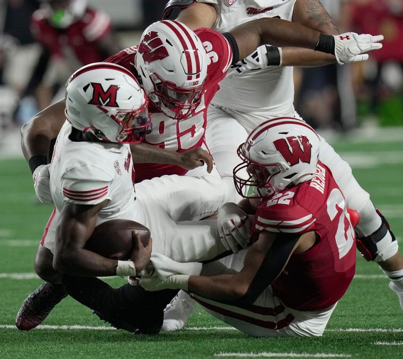 Miami (Ohio) quarterback Dequan Finn is sacked by Wisconsin defensive lineman Brandon Lane (95) and linebacker Mason Reiger (22) during the second quarter on Aug. 28 at Camp Randall Stadium.