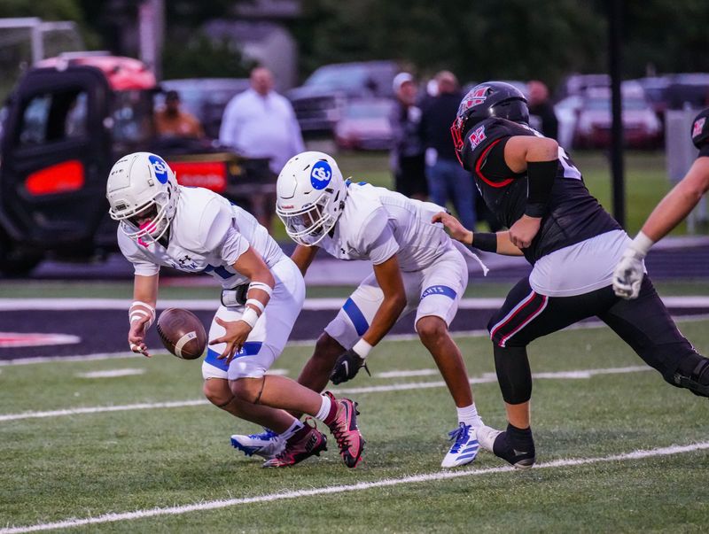 Oak Creek's Logan Bohn (37), left, attempts to pick up a fumble by teammate Jay Baylis-Hooker (1), center, on the opening kickoff in their football game against Muskego, Aug. 29, 2025 in Muskego, Wisconsin. Muskego recovered the ball.