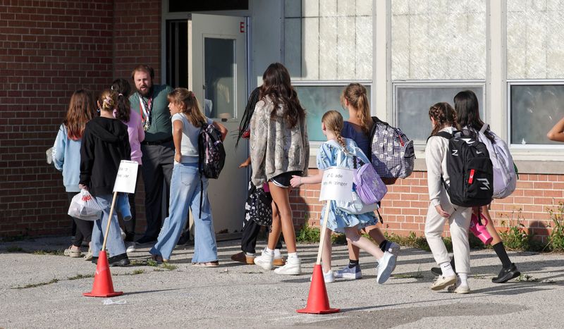 A teacher at Madison Elementary School greets returning students on the first day of classes, Tuesday, September 2, 2025, in Manitowoc, Wis.