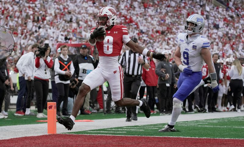 Wisconsin wide receiver Vinny Anthony II (8) scores a touchdown on a 14-yard run as Middle Tennessee linebacker Parker Hughes (9) looks on during the third quarter of the game Saturday, September 6, 2025 at Camp Randall Stadium in Madison, Wisconsin.