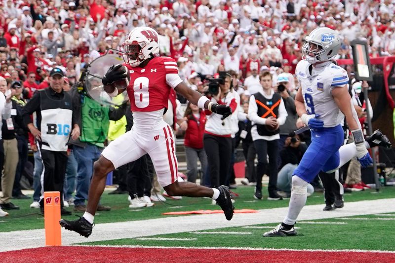 Sep 6, 2025; Madison, Wisconsin, USA; Wisconsin Badgers wide receiver Vinny Anthony II (8) scores against Middle Tennessee Blue Raiders linebacker Parker Hughes (9) during the second half at Camp Randall Stadium. Mandatory Credit: Kayla Wolf-Imagn Images