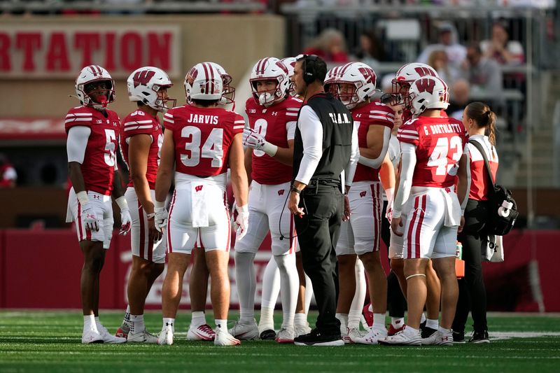 Sep 6, 2025; Madison, Wisconsin, USA; Wisconsin Badgers head coach Luke Fickell talks with his team during a timeout against the Middle Tennessee Blue Raiders during the second half at Camp Randall Stadium. Mandatory Credit: Kayla Wolf-Imagn Images