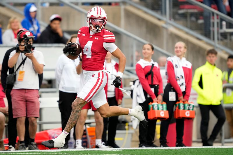 Sep 6, 2025; Madison, Wisconsin, USA; Wisconsin Badgers wide receiver Jayden Ballard (4) runs 58 yards for a touchdown against the Middle Tennessee Blue Raiders during the second half at Camp Randall Stadium. Mandatory Credit: Kayla Wolf-Imagn Images