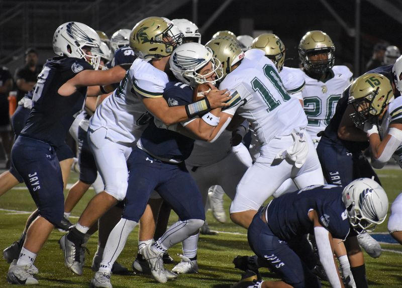 Menasha quarterback Paul Schmolinske is sandwiched by a pair of Oshkosh North defenders during a Fox River Classic Conference-South game Sept. 11, 2025, at Calder Stadium in Menasha.