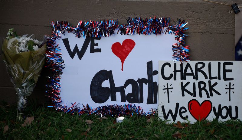People placed signs, flowers and candler by a makeshift memorial to honor Charlie Kirk at Riverside Park in New Smyrna Beach, Tuesday, Sept. 16, 2025.