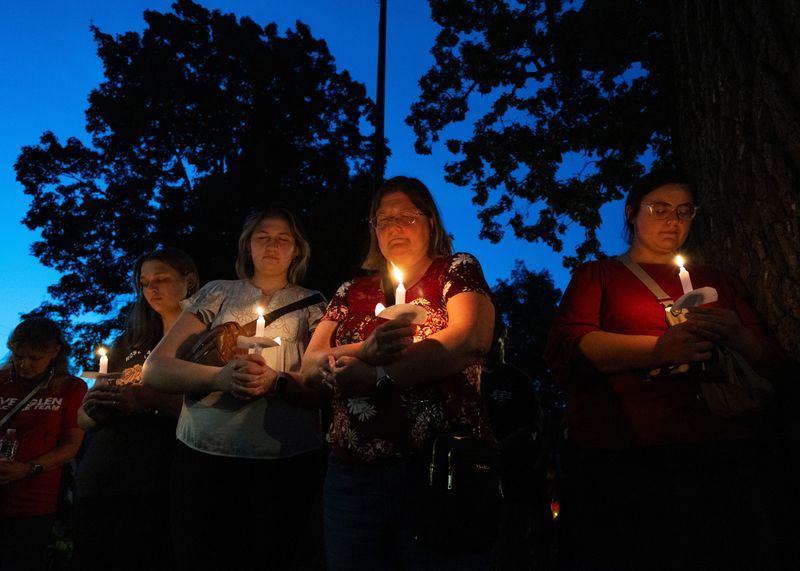 People pray while holding candles during a Remembering Charlie Kirk vigil hosted by the Wisconsin Young Republicans on Sept. 16 at Cutler Park in Waukesha.