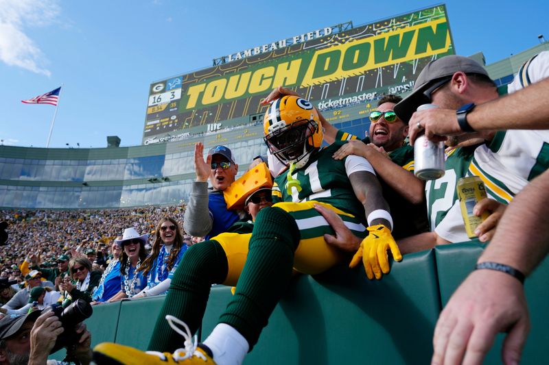 Sep 7, 2025; Green Bay, Wisconsin, USA; Green Bay Packers wide receiver Jayden Reed (11) celebrates with fans after scoring a touchdown against the Detroit Lions during the second quarter at Lambeau Field. Mandatory Credit: Jeff Hanisch-Imagn Images