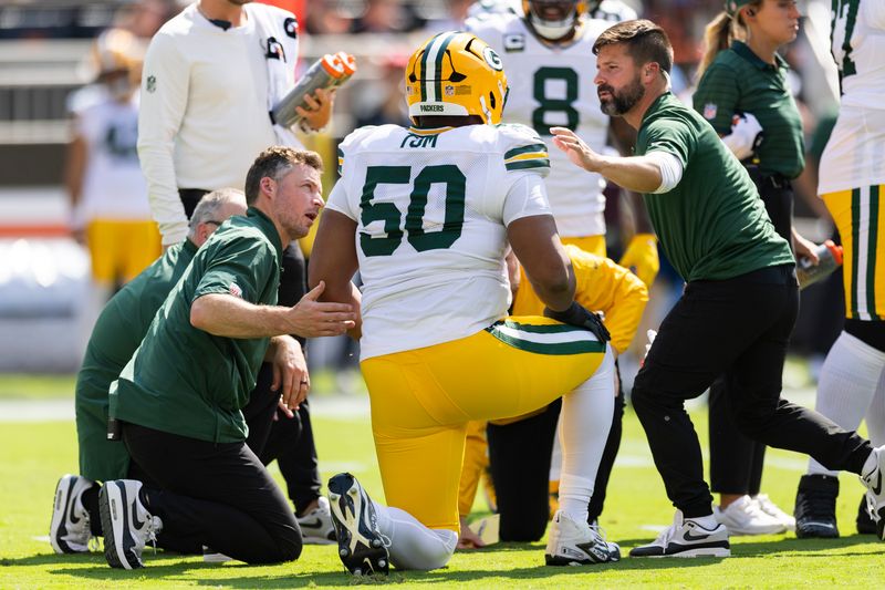 Sep 21, 2025; Cleveland, Ohio, USA; Green Bay Packers offensive tackle Zach Tom (50) is attended to by medical personnel for an on field injury during the first quarter against the Cleveland Browns at Huntington Bank Field. Mandatory Credit: Scott Galvin-Imagn Images