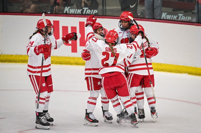 Teammates celebrate with Wisconsin defender Laila Edwards (back right) after her third-period goal, her second of the game, in a victory over Maine on Oct. 3 at LaBahn Arena in Madison.