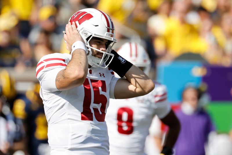 Oct 4, 2025; Ann Arbor, Michigan, USA; Wisconsin Badgers quarterback Hunter Simmons (15) covers his ears in the first half against the Michigan Wolverines at Michigan Stadium. Mandatory Credit: Rick Osentoski-Imagn Images