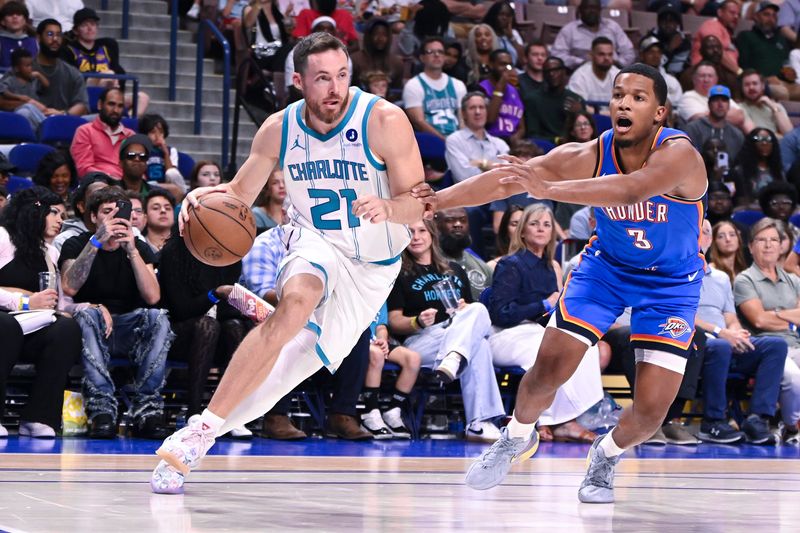Oct 5, 2025; North Charleston, South Carolina, USA; Pat Charlotte Hornets Connaughton (21) drives to the basket against Oklahoma City Thunder guard Chris Youngblood (3) in the fourth quarter at North Charleston Coliseum. Mandatory Credit: Arthur Ellis-Imagn Images