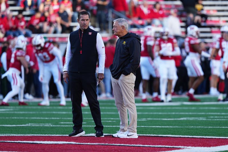 Oct 11, 2025; Madison, Wisconsin, USA; Wisconsin Badgers head coach Luke Fickell and Iowa Hawkeyes head coach Kirk Ferentz meet at mid field before the game at Camp Randall Stadium. Mandatory Credit: Ross Harried-Imagn Images