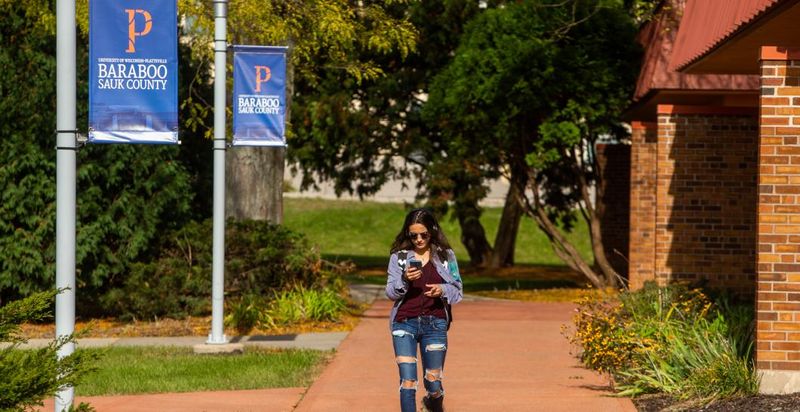 A woman walks on the UW-Platteville Baraboo Sauk County campus, which will close in May 2026.